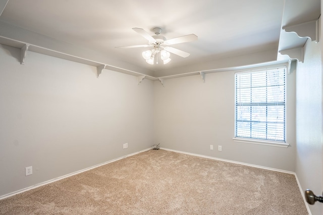 unfurnished room with carpet floors, baseboards, and a ceiling fan