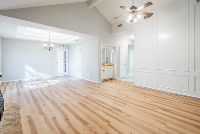 unfurnished living room featuring a raised ceiling, visible vents, light wood-style flooring, and beam ceiling