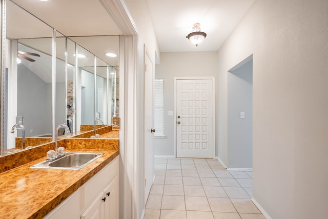 bathroom with baseboards, vanity, a ceiling fan, and tile patterned floors