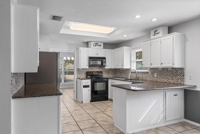 kitchen with white cabinetry, a healthy amount of sunlight, and black appliances