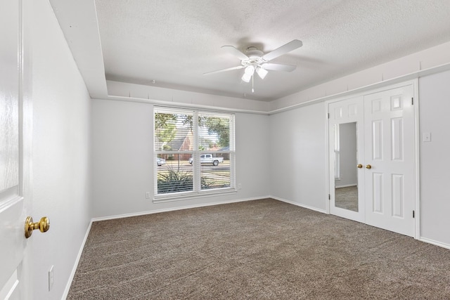 spare room with carpet flooring, ceiling fan, and a textured ceiling