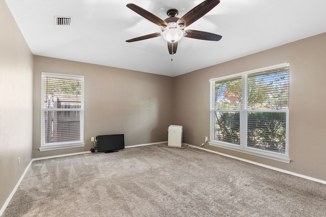 empty room featuring ceiling fan and light carpet