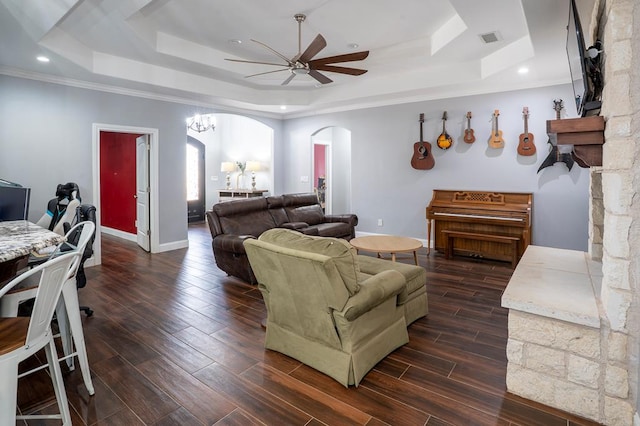 living area with visible vents, arched walkways, a raised ceiling, dark wood-style floors, and ceiling fan