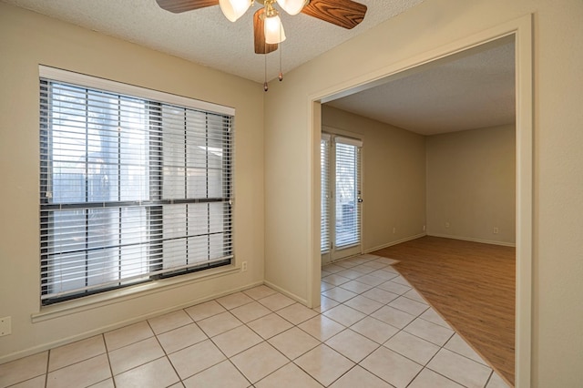 spare room with ceiling fan, a textured ceiling, and light hardwood / wood-style flooring