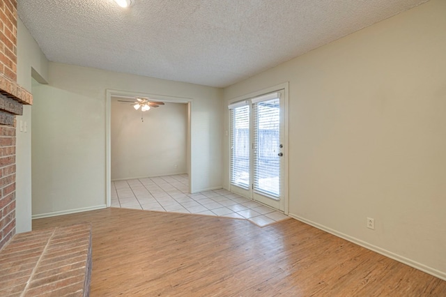 unfurnished room with a textured ceiling, light hardwood / wood-style floors, and ceiling fan