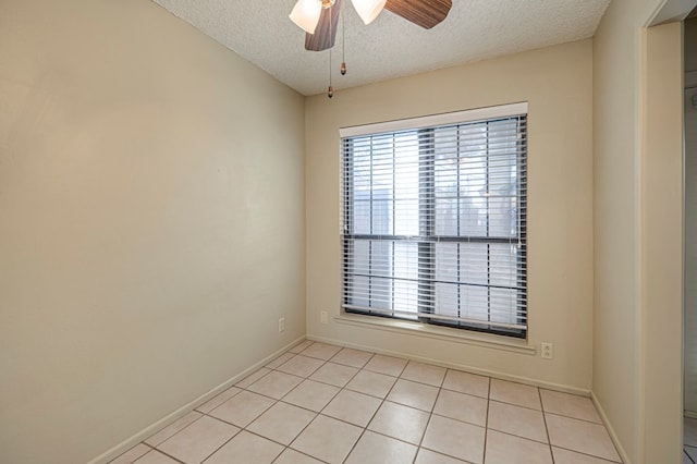 tiled spare room featuring ceiling fan and a textured ceiling