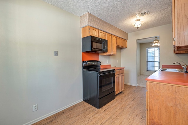 kitchen featuring light wood-type flooring, a textured ceiling, ceiling fan, sink, and black appliances