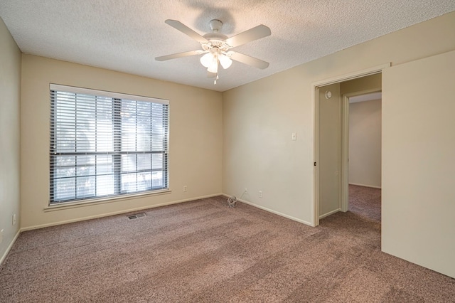 carpeted empty room with ceiling fan and a textured ceiling