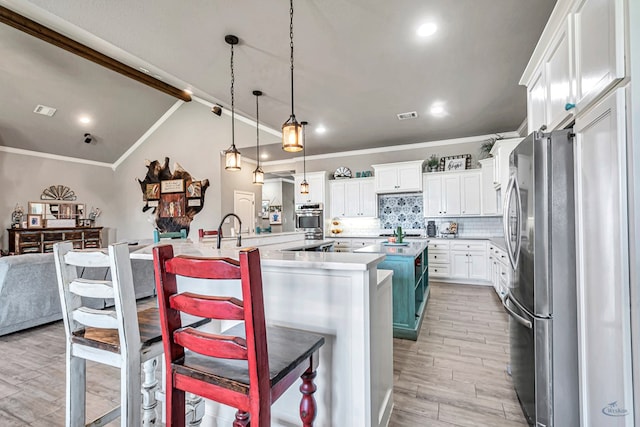 6811 W County Rd 41, Midland, TX 79707 - kitchen with stainless steel appliances, a spacious island, crown molding, light wood-style flooring, and decorative backsplash