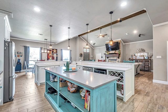 6811 W County Rd 41, Midland, TX 79707 - kitchen featuring a large island with sink, stainless steel appliances, a ceiling fan, light wood-style floors, and lofted ceiling