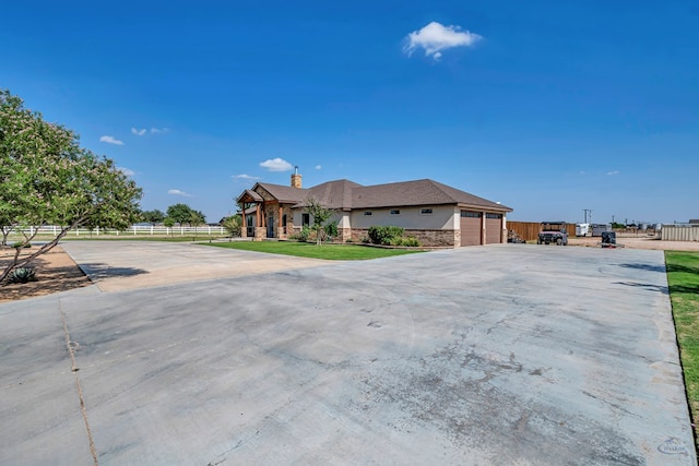 6811 W County Rd 41, Midland, TX 79707 - view of front facade with a garage, driveway, a chimney, and stone siding