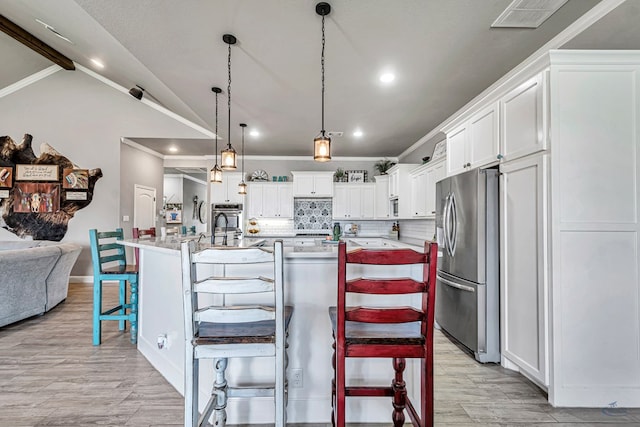 6811 W County Rd 41, Midland, TX 79707 - kitchen featuring stainless steel appliances, light wood-style floors, recessed lighting, white cabinetry, and a kitchen bar