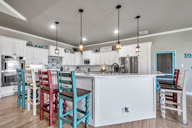 6811 W County Rd 41, Midland, TX 79707 - kitchen with stainless steel appliances, crown molding, a large island, tasteful backsplash, and light wood-type flooring