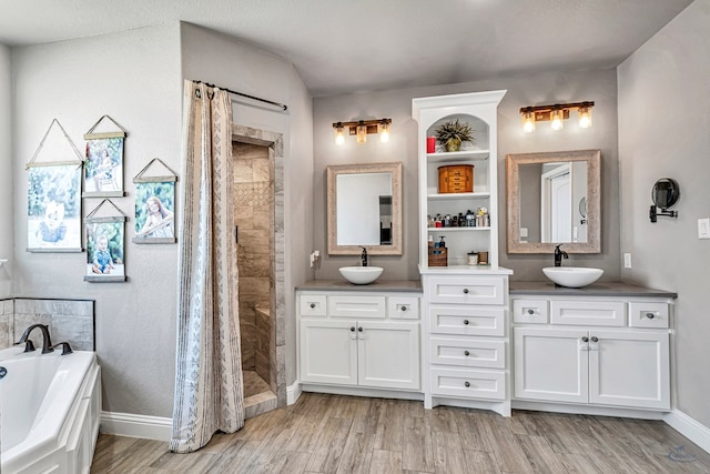 6811 W County Rd 41, Midland, TX 79707 - full bath featuring wood finished floors, double vanity, a bath, a tile shower, and baseboards