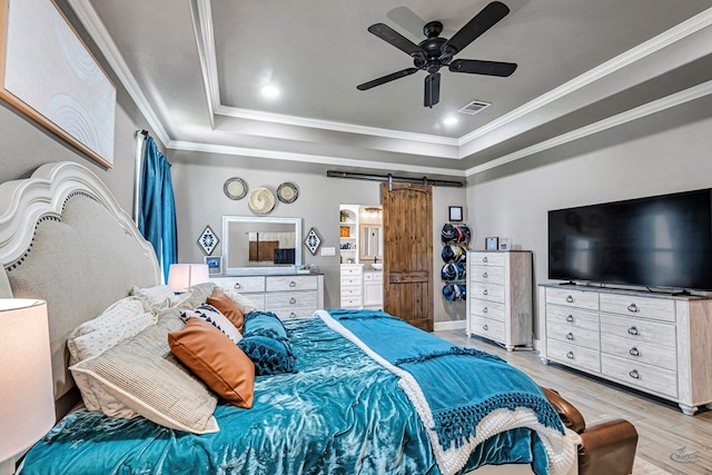 6811 W County Rd 41, Midland, TX 79707 - bedroom with a barn door, a raised ceiling, crown molding, light wood-type flooring, and a ceiling fan