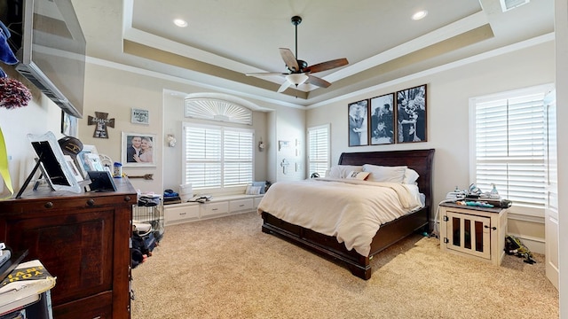 bedroom featuring light carpet, a ceiling fan, a tray ceiling, crown molding, and recessed lighting