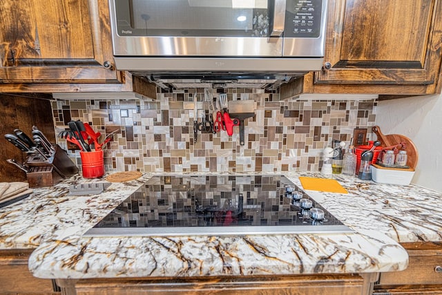 room details featuring stainless steel microwave, light countertops, and backsplash