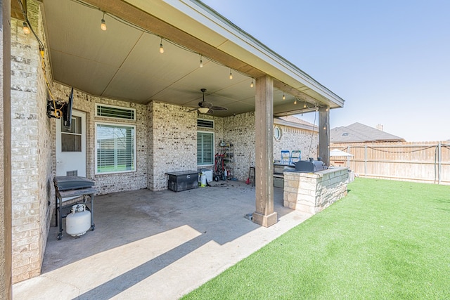 view of patio with ceiling fan, a grill, fence, and area for grilling