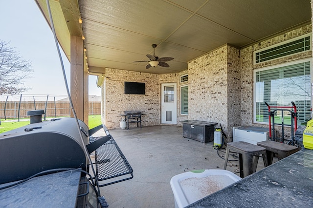 view of patio featuring grilling area, fence, and a ceiling fan