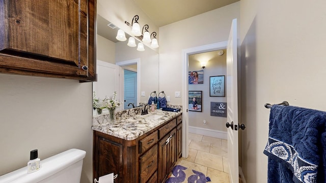 bathroom featuring vanity, toilet, and baseboards