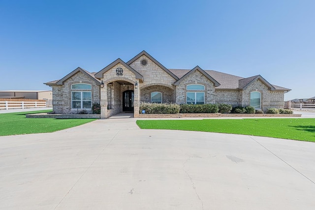 french country style house with fence and a front lawn