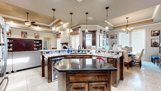 kitchen with a spacious island, wine cooler, a raised ceiling, and a sink