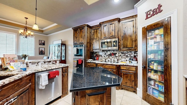 kitchen with light tile patterned floors, decorative backsplash, ornamental molding, a tray ceiling, and stainless steel appliances