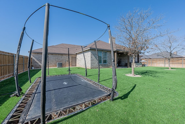 view of yard featuring a fenced backyard and a trampoline