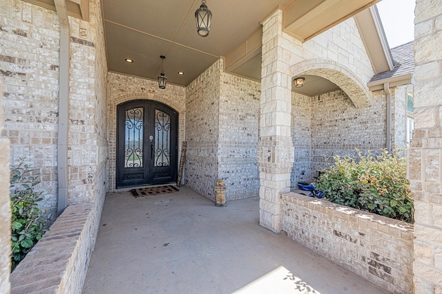 property entrance featuring french doors and brick siding