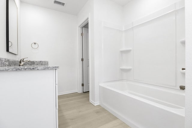 804 Bella Bvd, Coleman, TX 76834 - bathroom featuring wood finished floors, vanity, and shower / washtub combination
