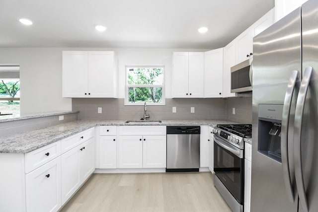 804 Bella Bvd, Coleman, TX 76834 - kitchen featuring stainless steel appliances, a peninsula, light wood finished floors, white cabinetry, and recessed lighting