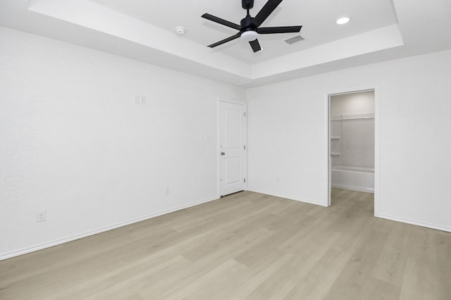 804 Bella Bvd, Coleman, TX 76834 - unfurnished bedroom with a raised ceiling, light wood-style flooring, recessed lighting, ceiling fan, and a walk in closet