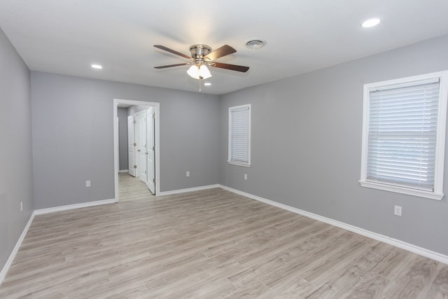 empty room featuring light wood-type flooring, visible vents, and baseboards