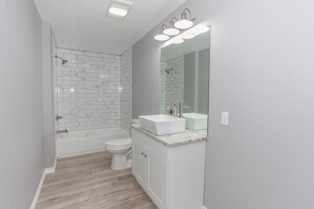 bathroom with shower / bath combination, baseboards, toilet, wood finished floors, and vanity