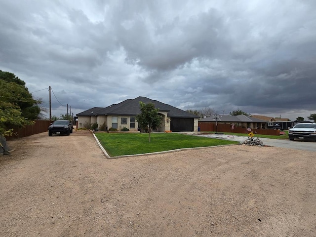 ranch-style house with a front lawn, fence, and dirt driveway