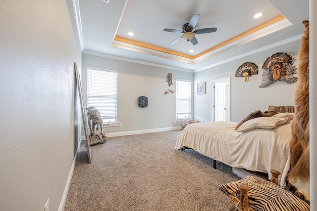 bedroom with baseboards, a ceiling fan, ornamental molding, carpet, and a tray ceiling