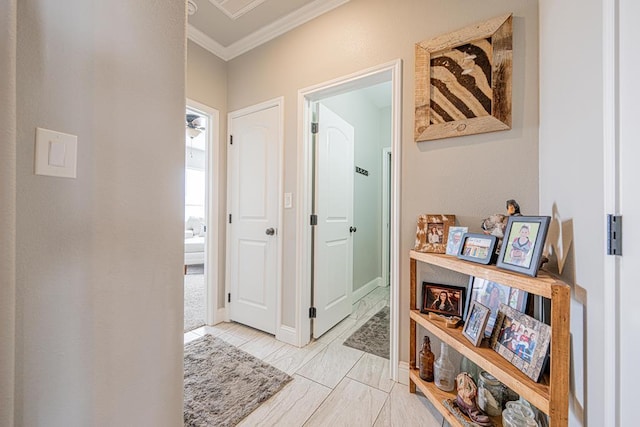 hallway featuring baseboards and crown molding