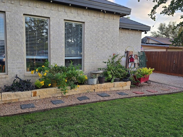 view of property exterior featuring a yard and fence