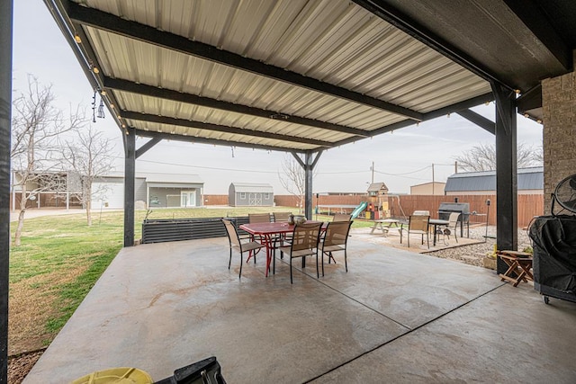 view of patio / terrace featuring outdoor dining area, a playground, and fence