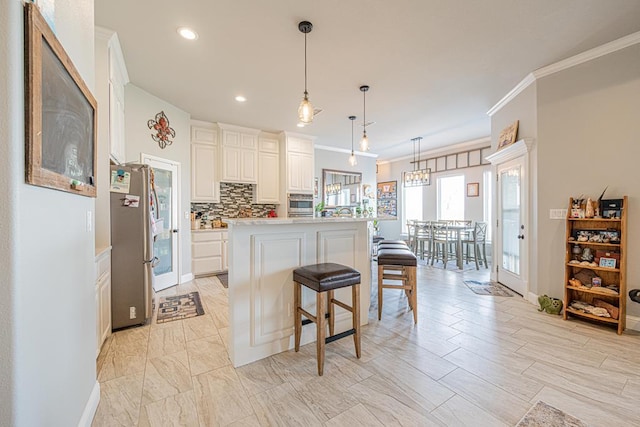 kitchen with a kitchen breakfast bar, hanging light fixtures, stainless steel appliances, light countertops, and backsplash