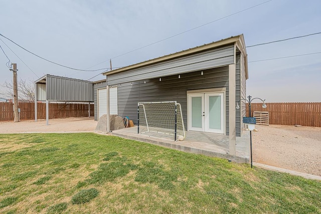 rear view of property with french doors, a lawn, and fence