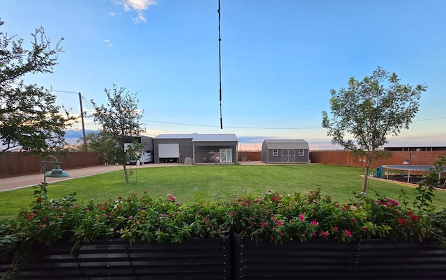 exterior space featuring a storage unit, a trampoline, an outdoor structure, and a fenced backyard