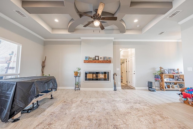 interior space with coffered ceiling, a glass covered fireplace, visible vents, and crown molding