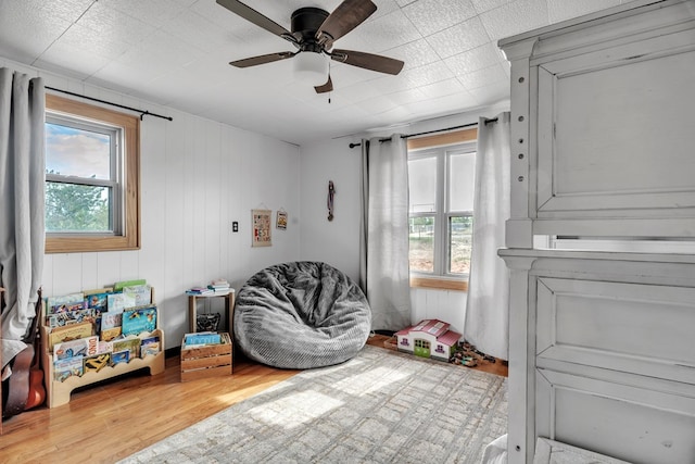 living area featuring wood finished floors and a ceiling fan