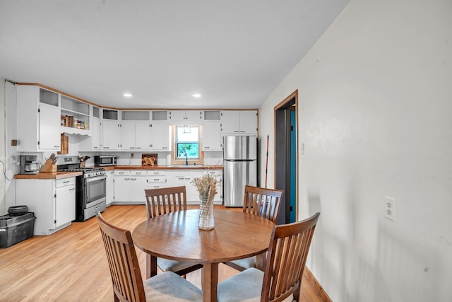 dining space with light wood finished floors and recessed lighting