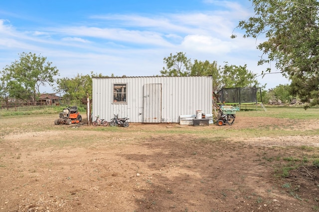 view of outdoor structure with a trampoline and an outbuilding