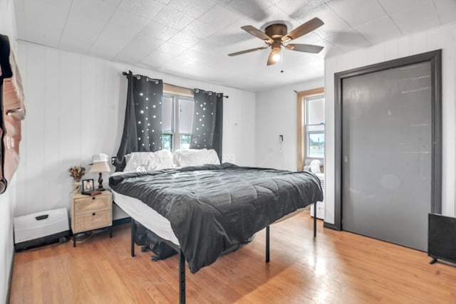 bedroom with multiple windows, light wood-type flooring, and ceiling fan