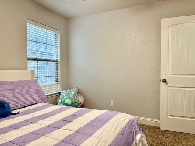 bedroom with baseboards and carpet