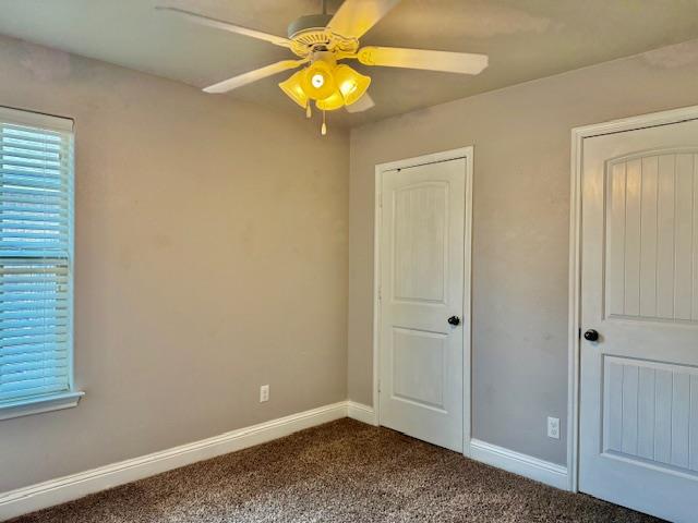 606 Memorial Ct, Midland, TX 79706 - unfurnished bedroom with dark colored carpet, baseboards, and a ceiling fan