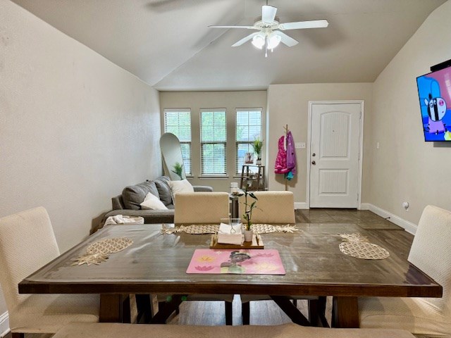 dining room featuring baseboards, ceiling fan, and vaulted ceiling